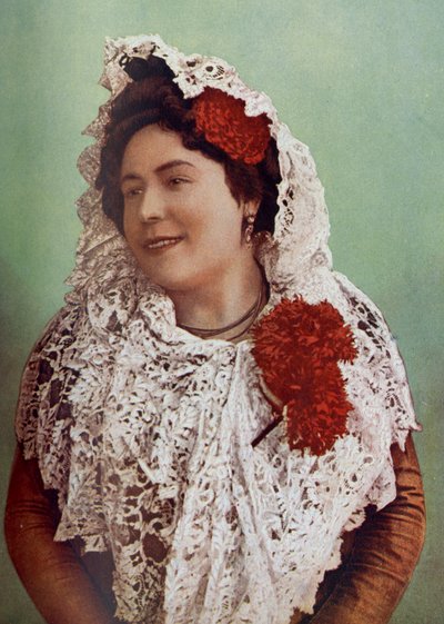 España. Flores escarlata y mantilla de encaje blanco sobre el cabello y los hombros muestran la belleza sureña de la andaluza. 1920 de Unknown